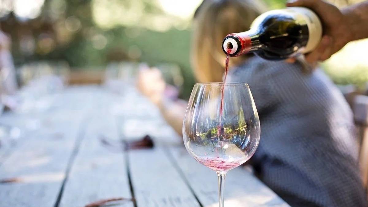 man pouring wine into wine glass